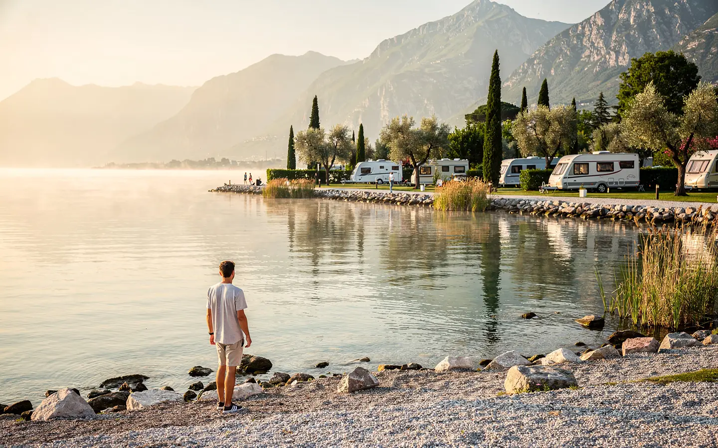 Ruhiger früher Morgen am Gardasee mit wenigen Spaziergängern und Paddlern