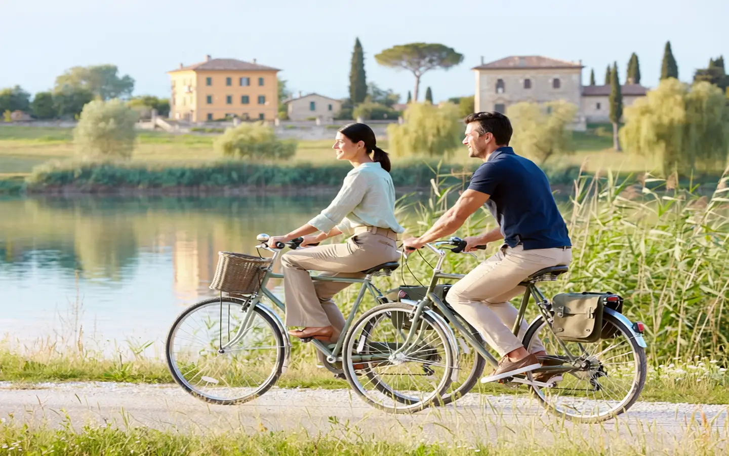 Cyclists among vineyards and olive groves in the Bardolino hinterland with Lake Garda in the background